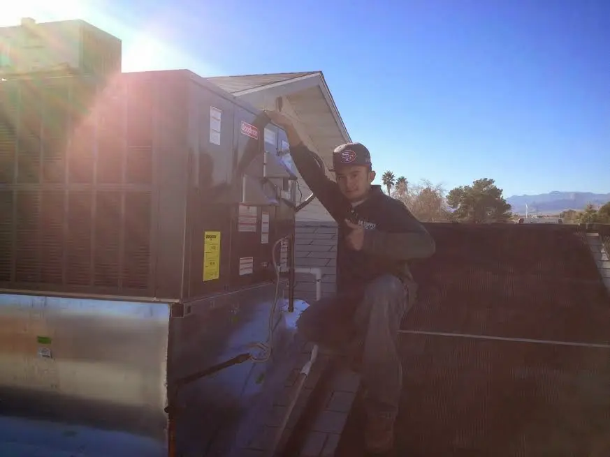 HVAC technician performing Boiler Repair on a rooftop unit in Wayland
